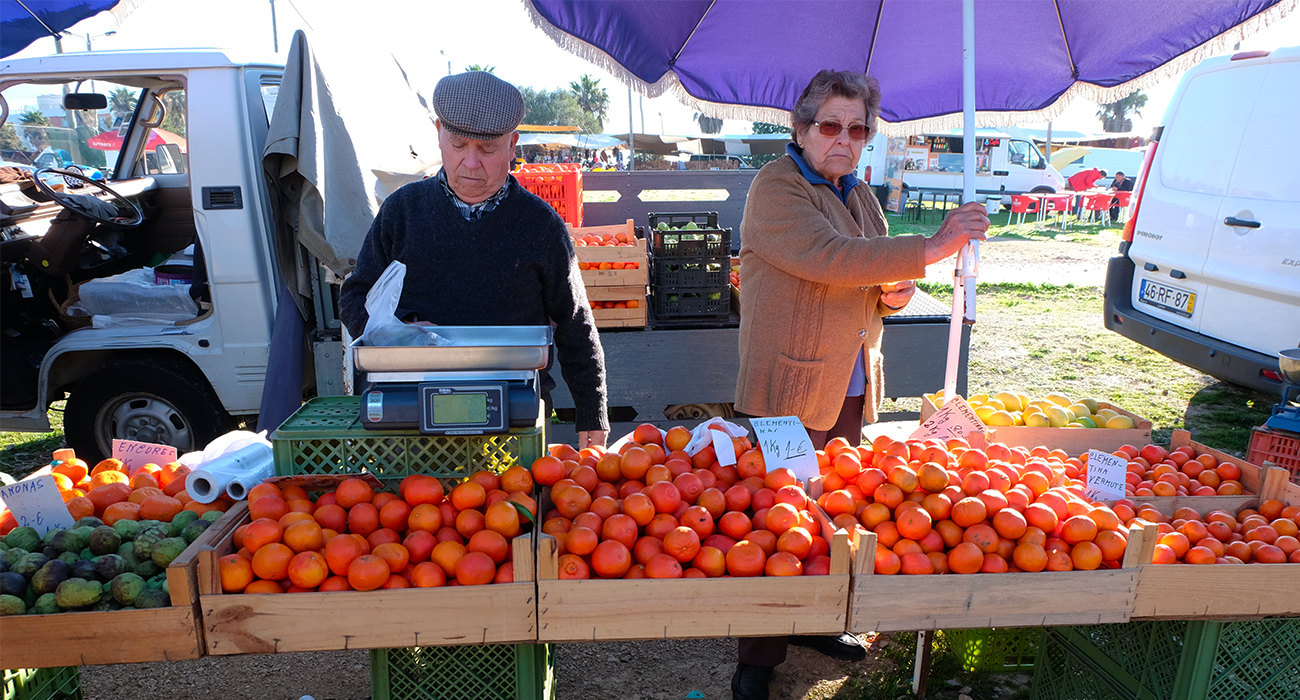 Photo de 2 personnes agees vendant des oranges au marché d'Albufeira