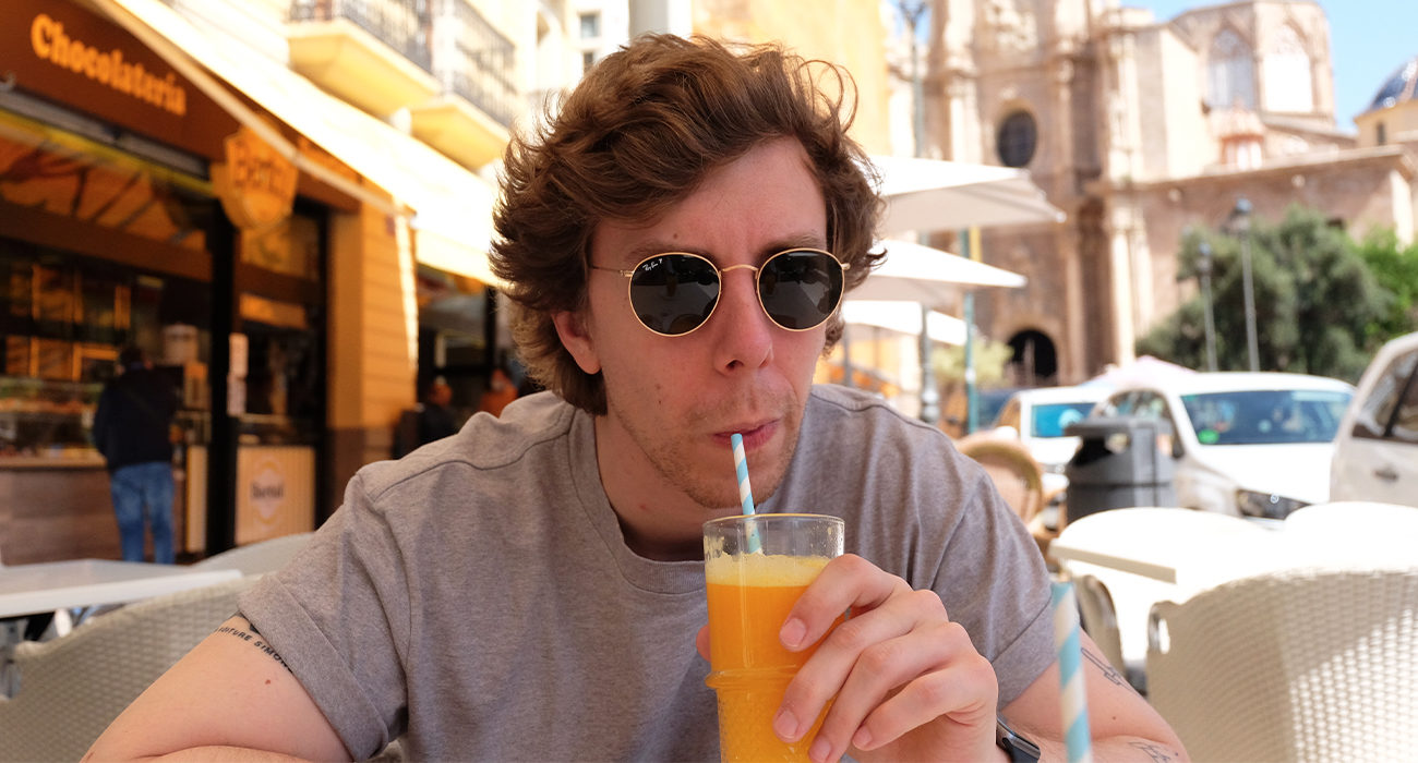 Siroter un jus d'orange à une terrasse 